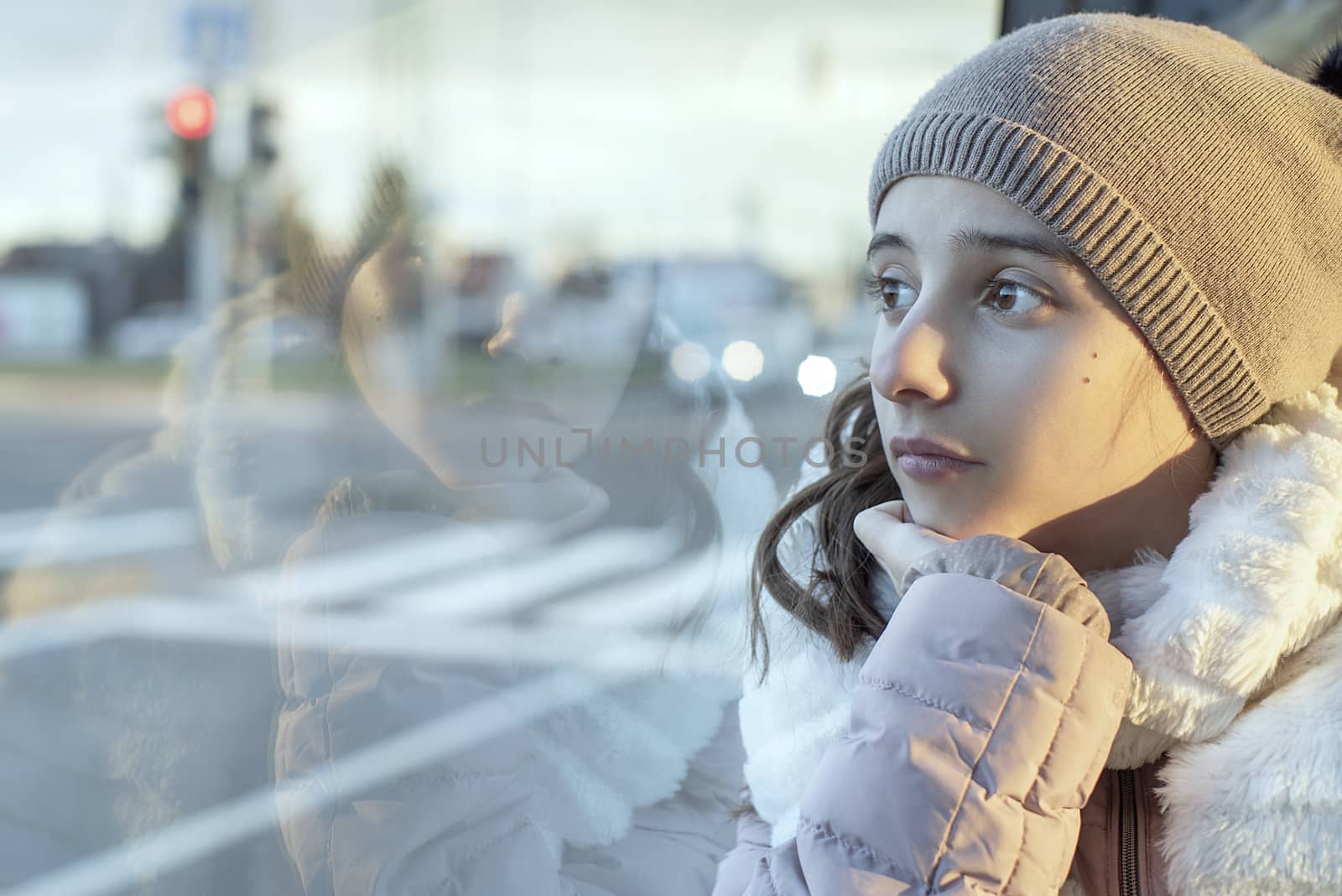 Teenager girl.Girl teenager sits on the bus and looks out the window,teenager girl is sitting in the bus looking forward thinking.