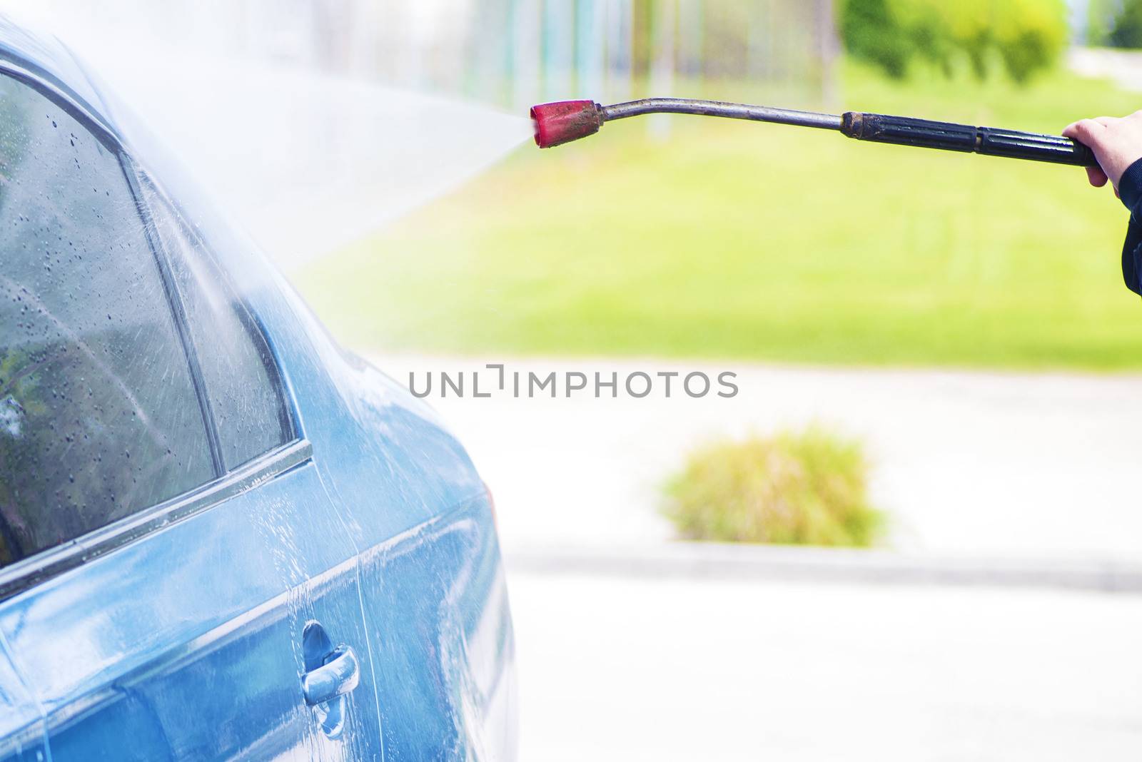 Cleaning Car Using High Pressure Water.Manual car wash with pressurized water in car wash outside.