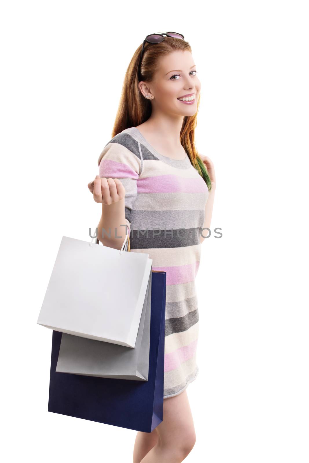 Shopping concept. Portrait of a beautiful smiling young girl in a dress, holding a lot of shopping bags, isolated on white background.