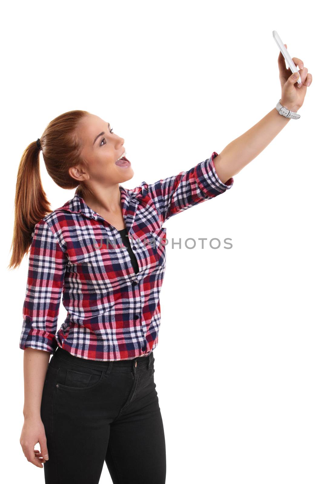Smiling beautiful young girl dressed in casual clothes taking a selfie, isolated on white background.