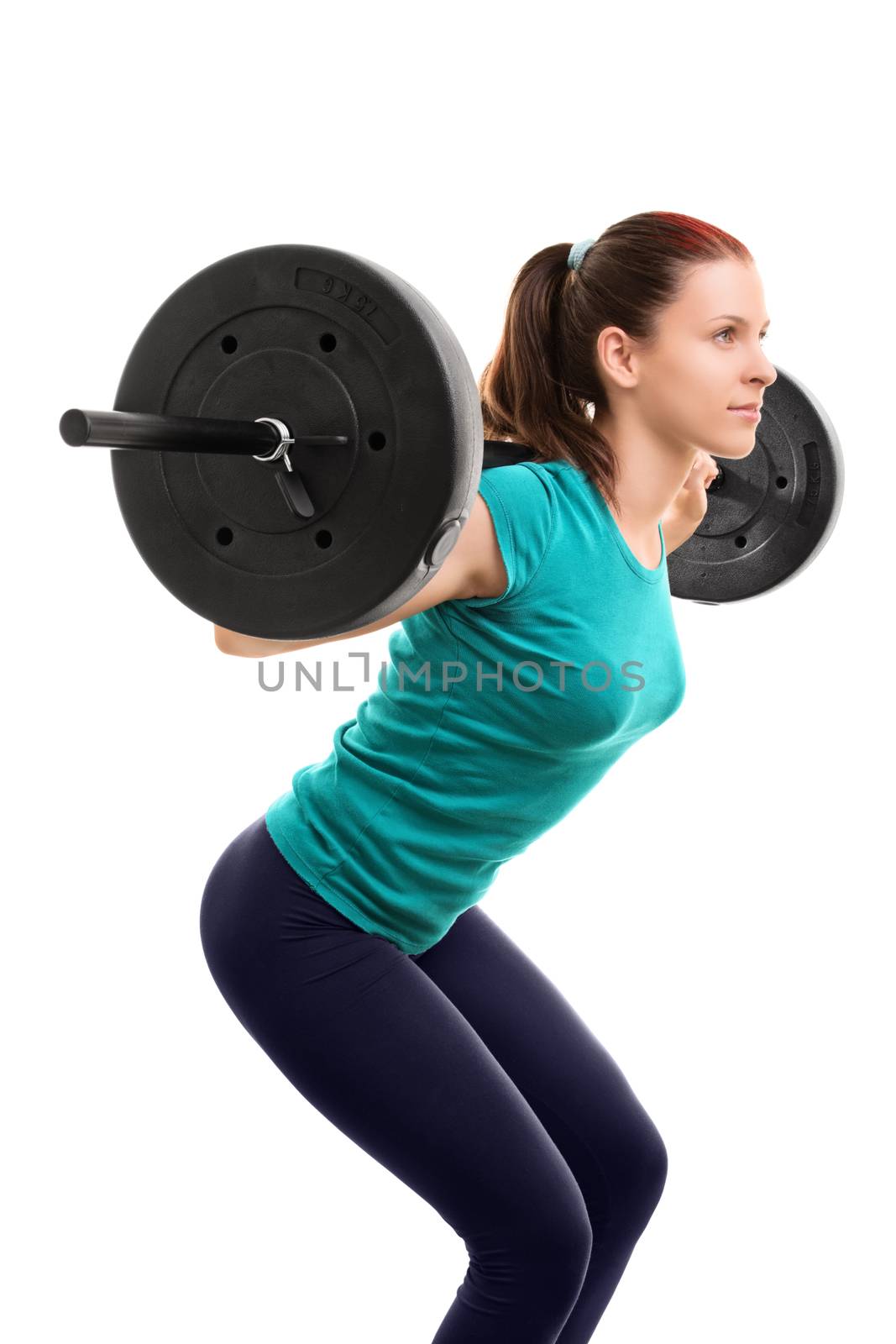 Beautiful fit young girl with barbell doing squats, isolated on white background.