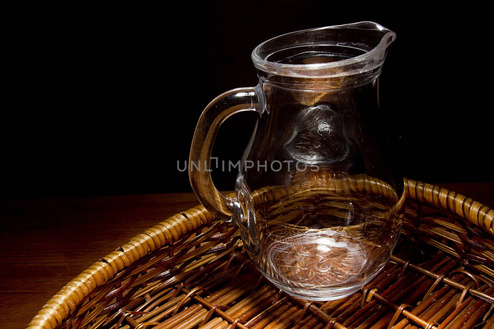 Empty glass jug in a wicker basket