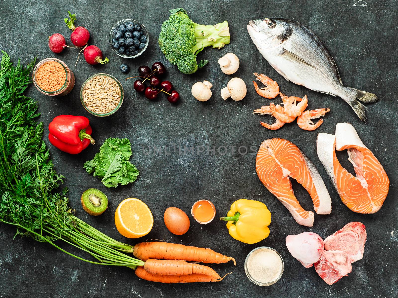 Food rich in collagen concept. Various food ingredients and chalkboard with copy space in center over dark background. Top view or flat lay