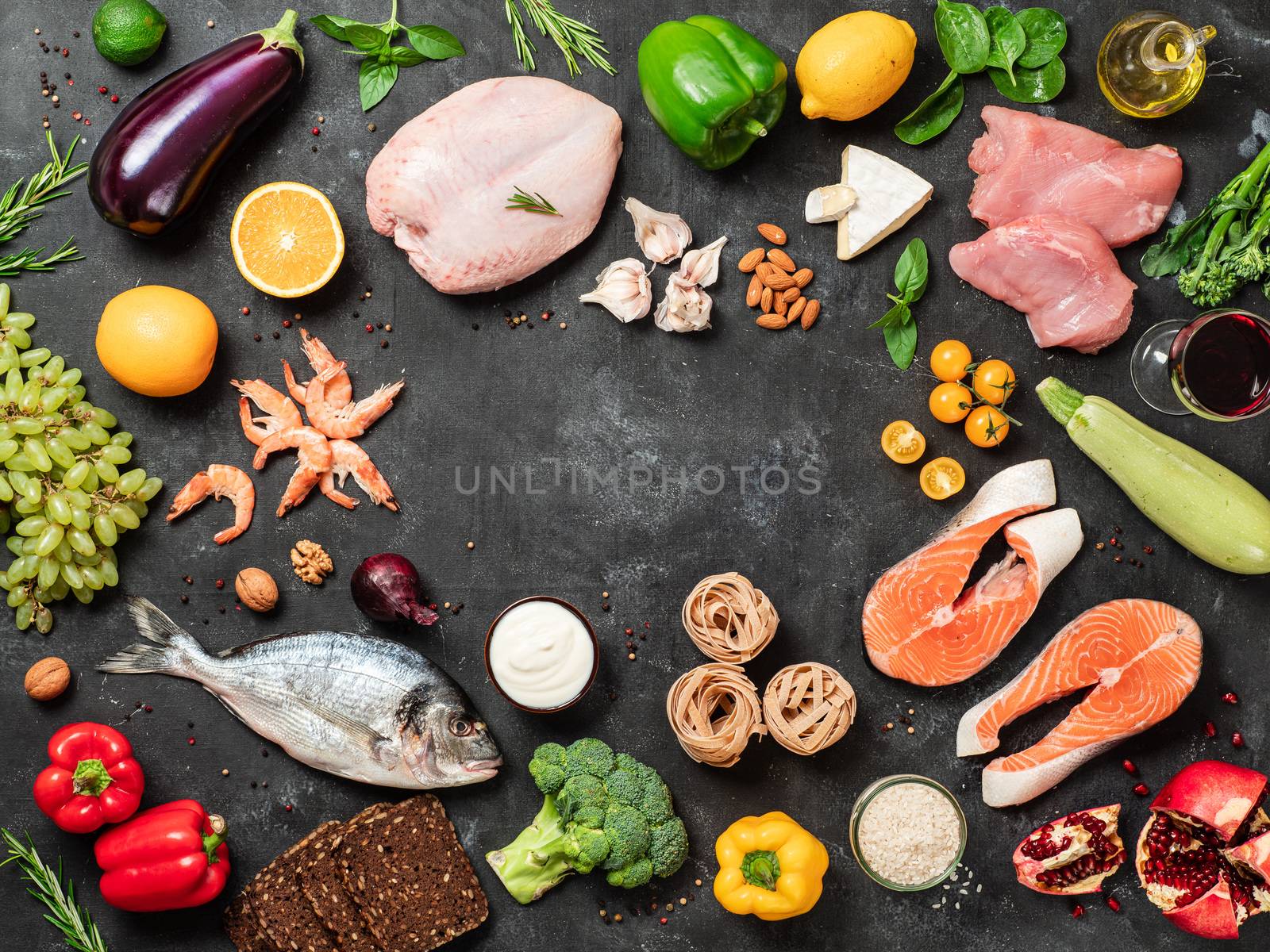 Mediterranean diet concept with copy space in center. Top view of selective food ingredients of Mediterranean Diet on dark background. Flat lay.