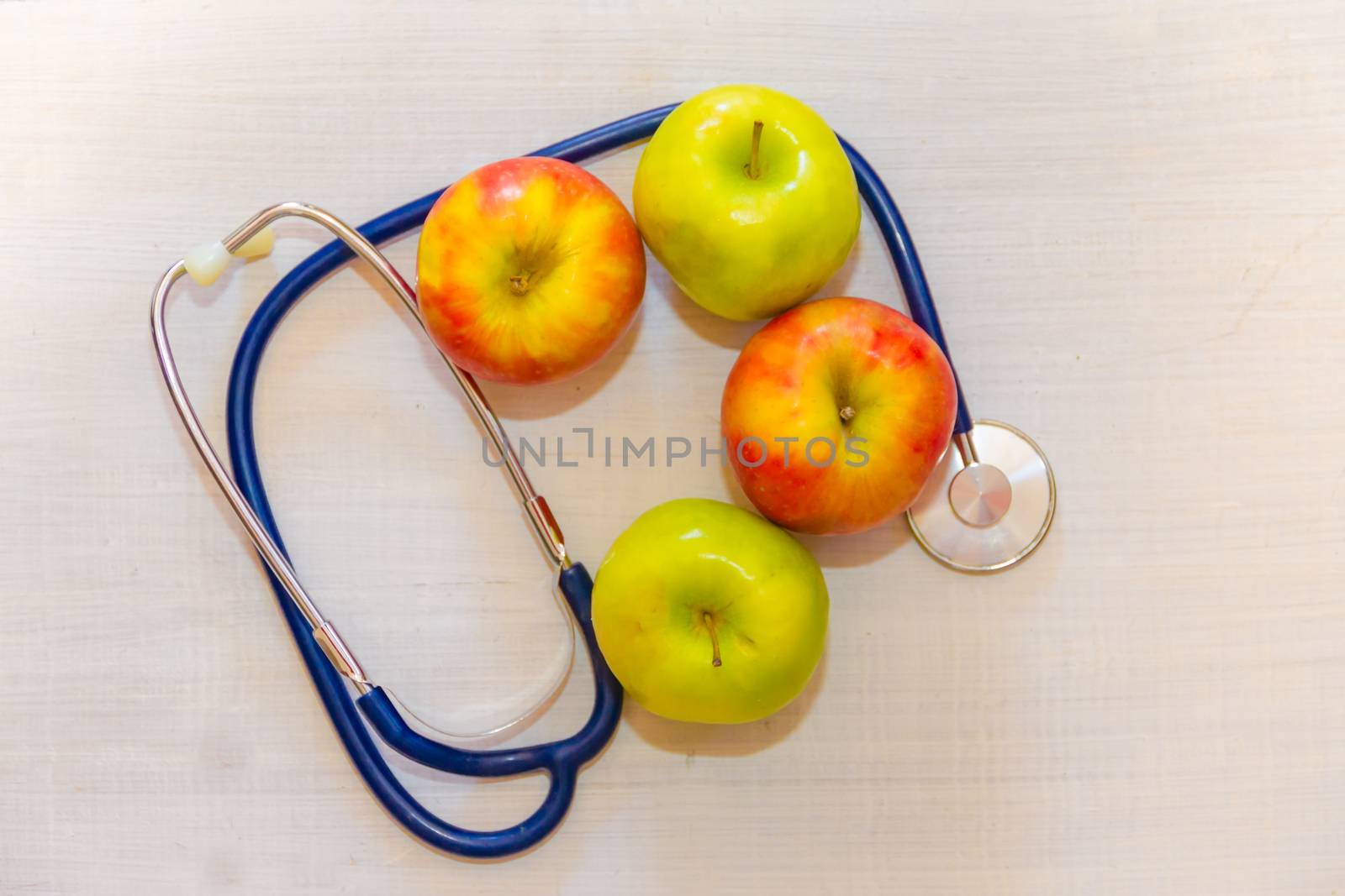 health concept with green and red apples and stethoscope by GabrielaBertolini