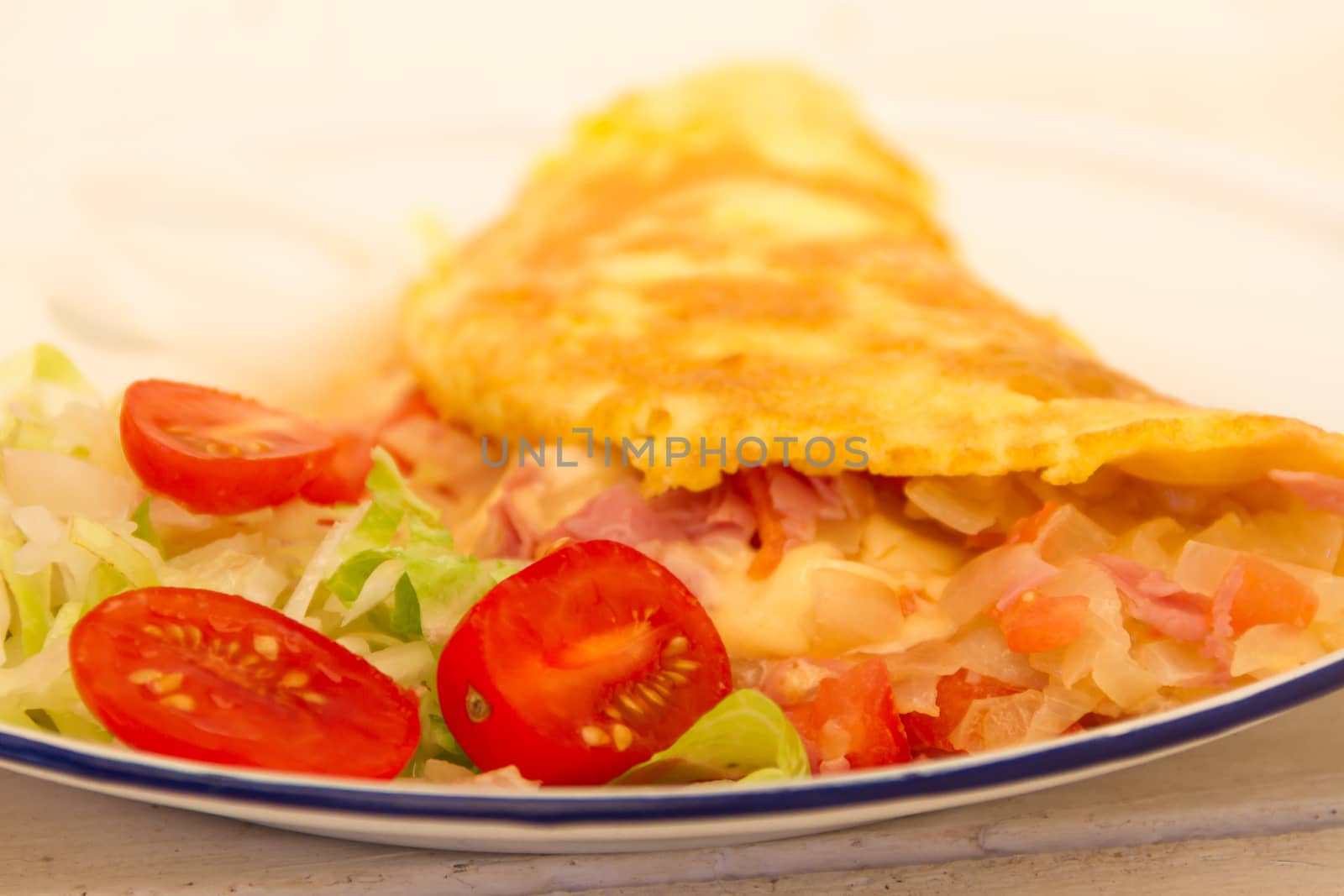 plate with omelette and salad of cherry tomatoes and lettuce