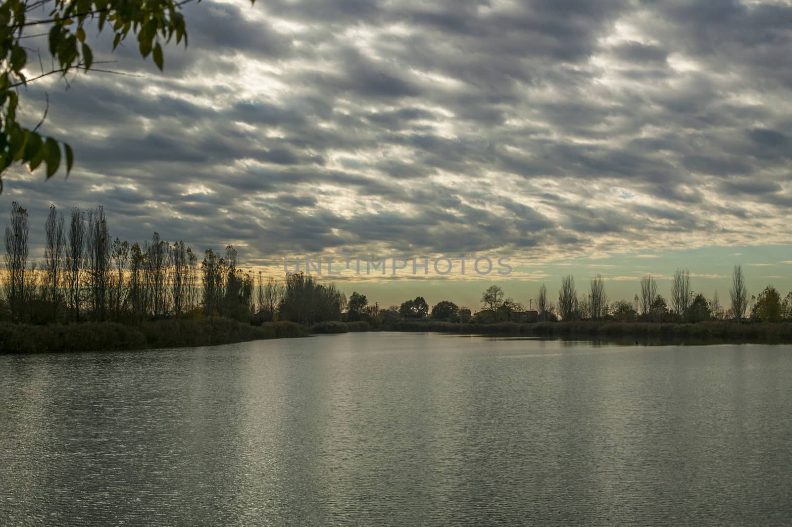 Magnificent sunset with cloudy sky and lake view: a natural spectacle that gives unique colors and emotions.