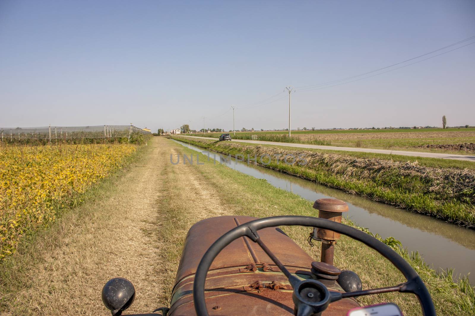 First-person image in driving a vintage tractor to cultivate farm fields and campaign.