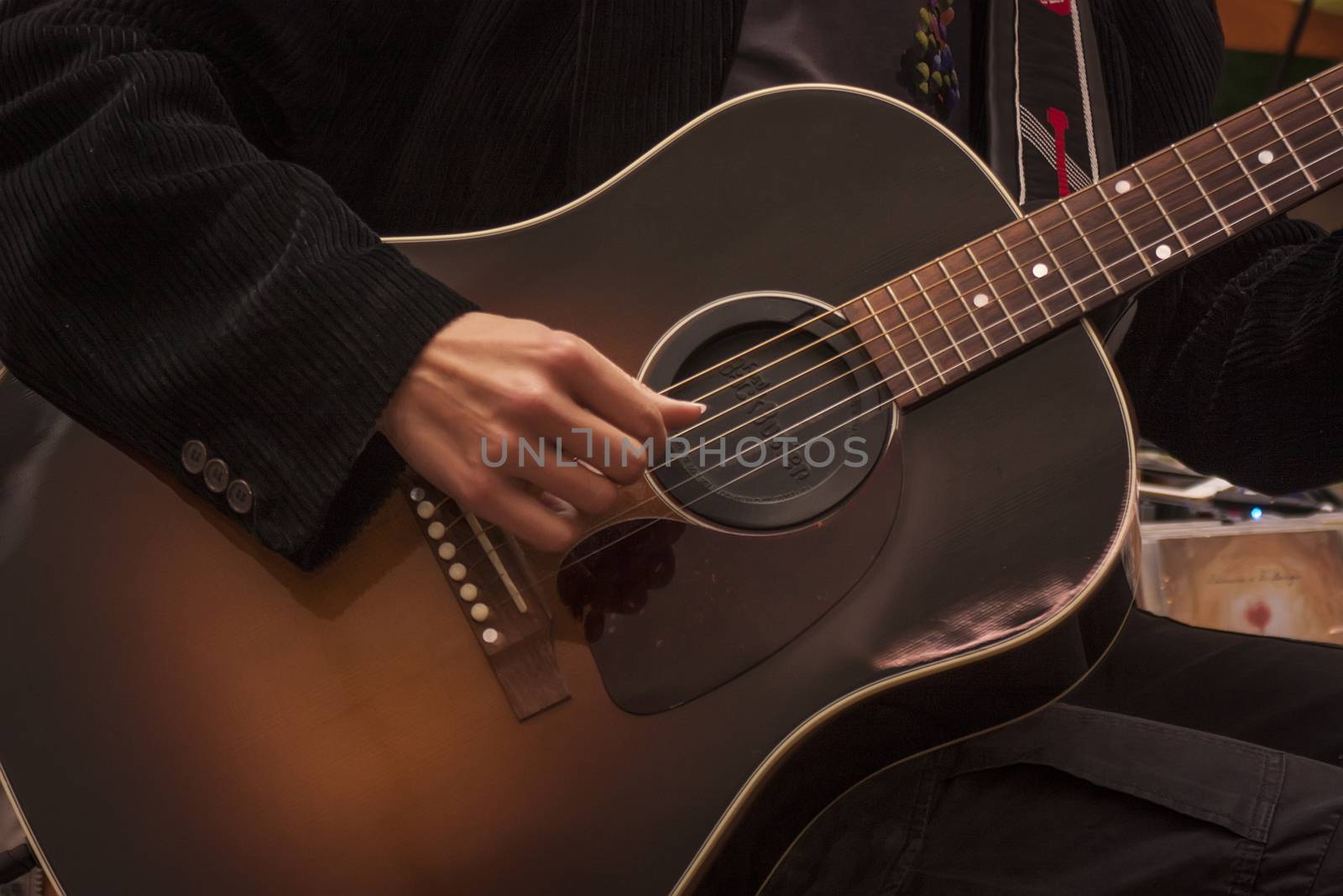 Image of a traditional guitar while being played by a musician.