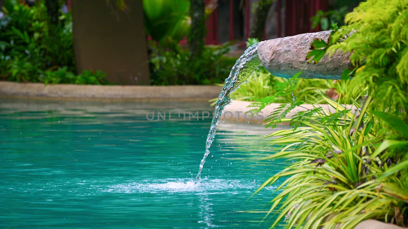 Water flowing water falling into the pond, decoration of the edge of the poo by sarayut_thaneerat