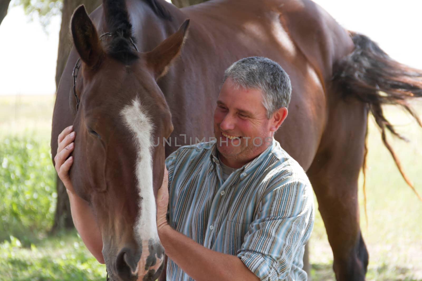 Smiling man with his horse in the Argentine countryside by GabrielaBertolini
