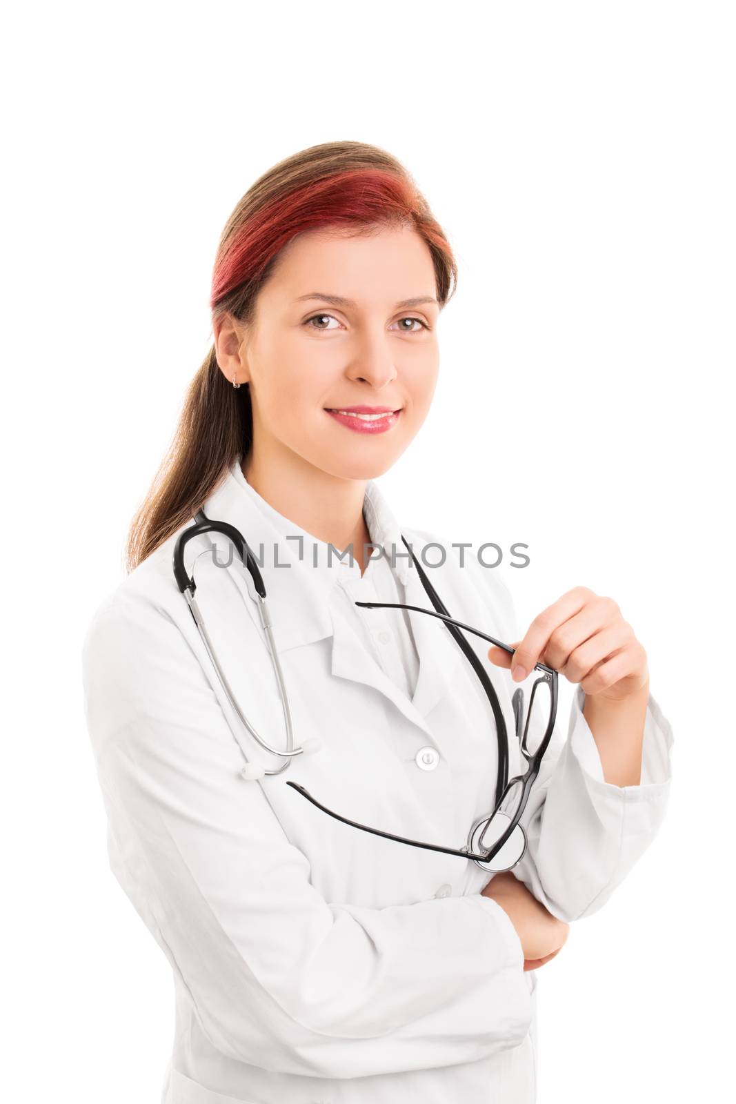 Portrait of a smiling young female health care professional or doctor or nurse with a stethoscope around her neck holding glasses, isolated on white background. Caring and confident face for your health.