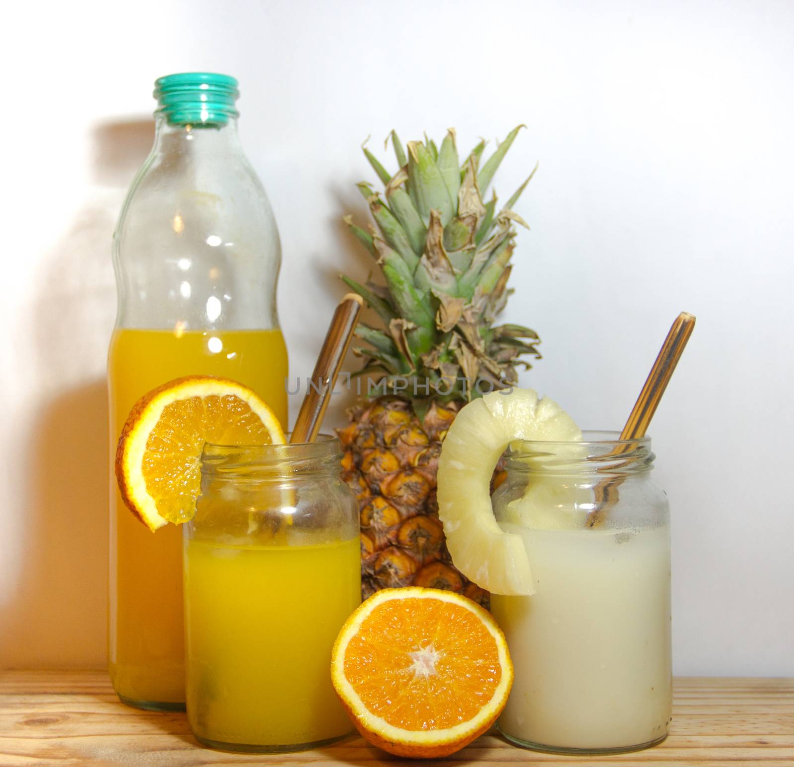 Juices smoothies and fresh pineapple and orange drinks with summer fruits