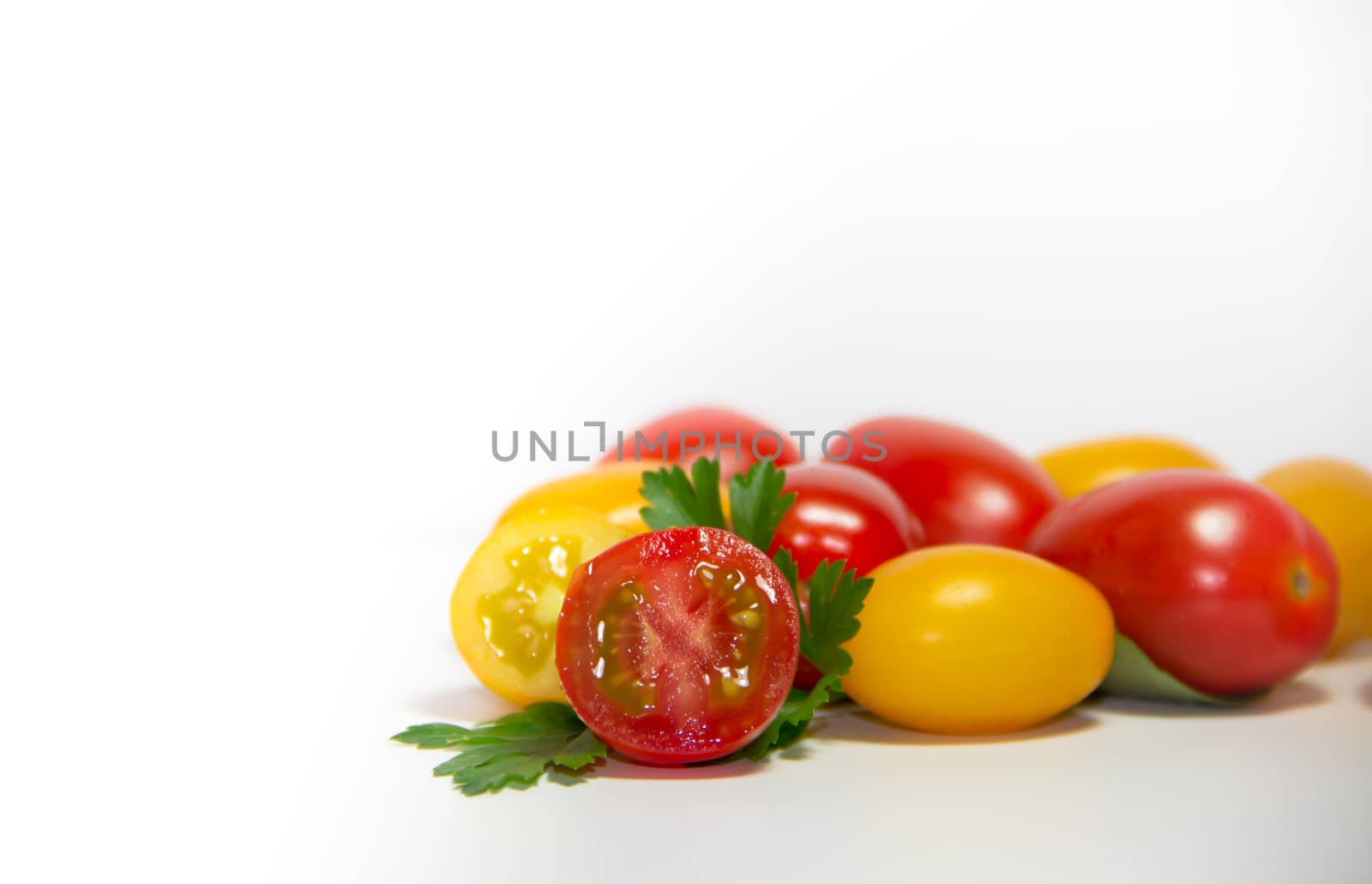 red and yellow cherry tomatoes on white background by GabrielaBertolini