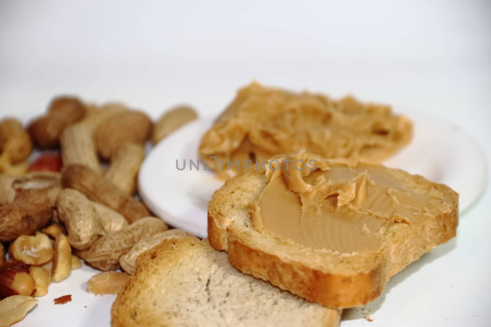 toast with peanut butter on white background by GabrielaBertolini