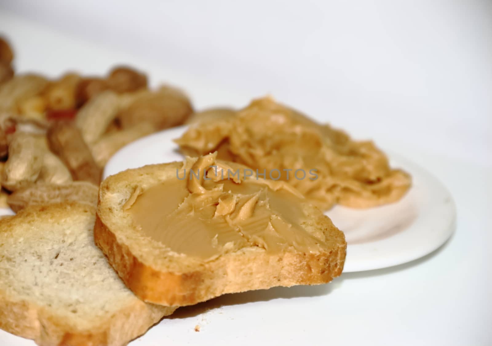 toast with peanut butter on white background by GabrielaBertolini