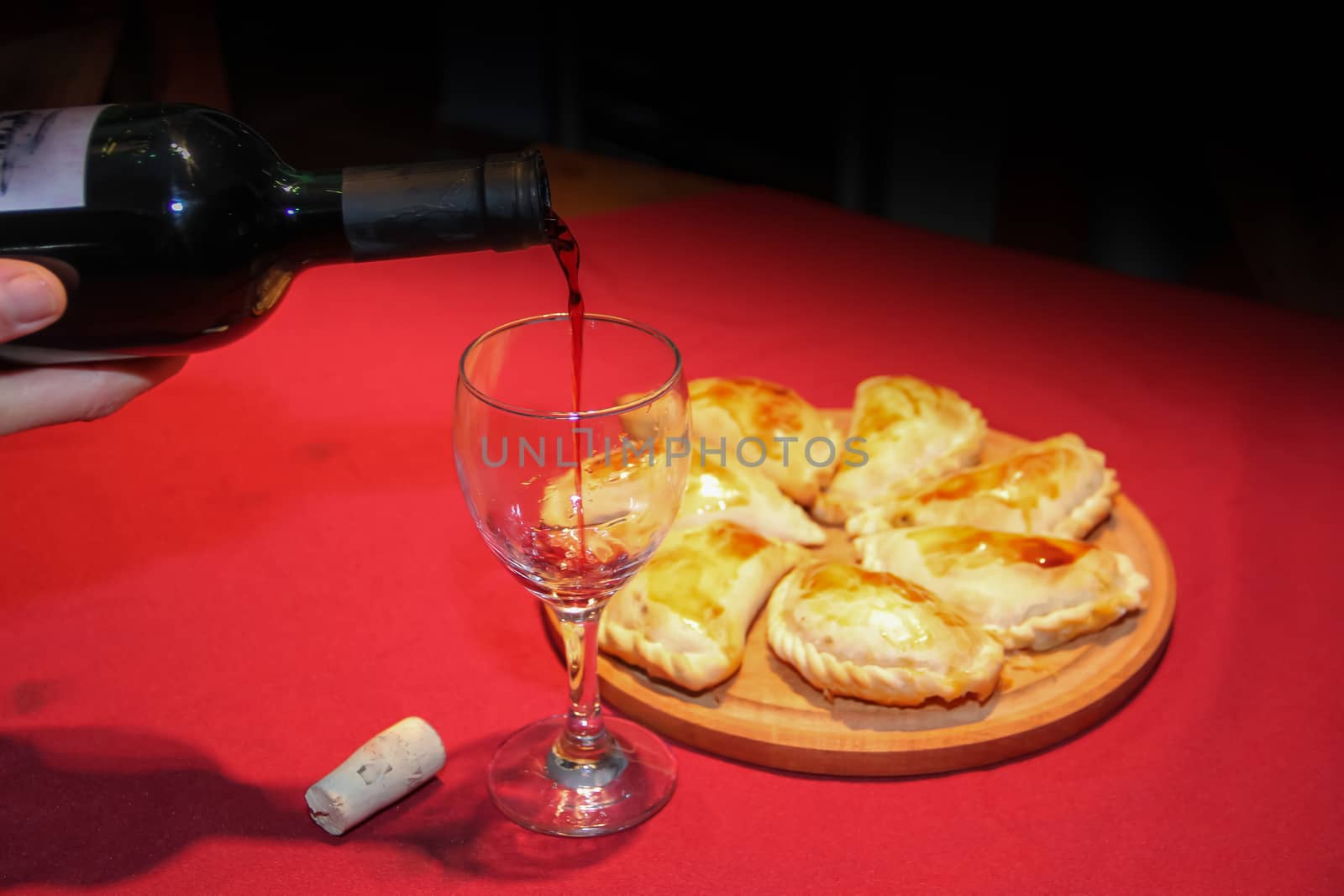 serving wine in the glass with empanadas plate typical South American food