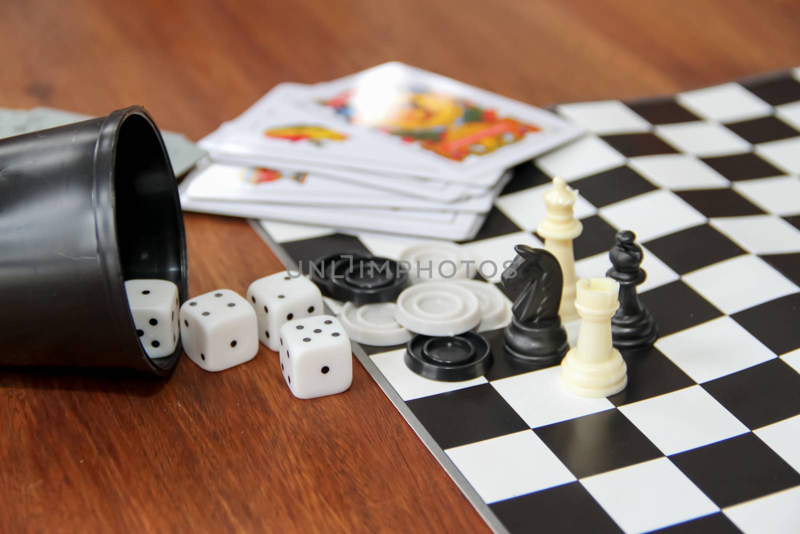 mix of goblet table games dice spanish poker cards chess and checkers