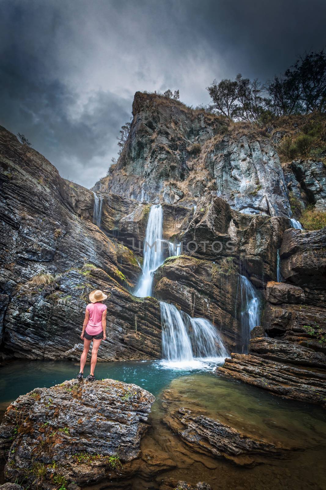 Waterfalls tumbling from over and within imposing rocky limestone gorge and caves flow into stunning blue swimming holes.  Moody weather of the Snowy Mountains rumbles overhead