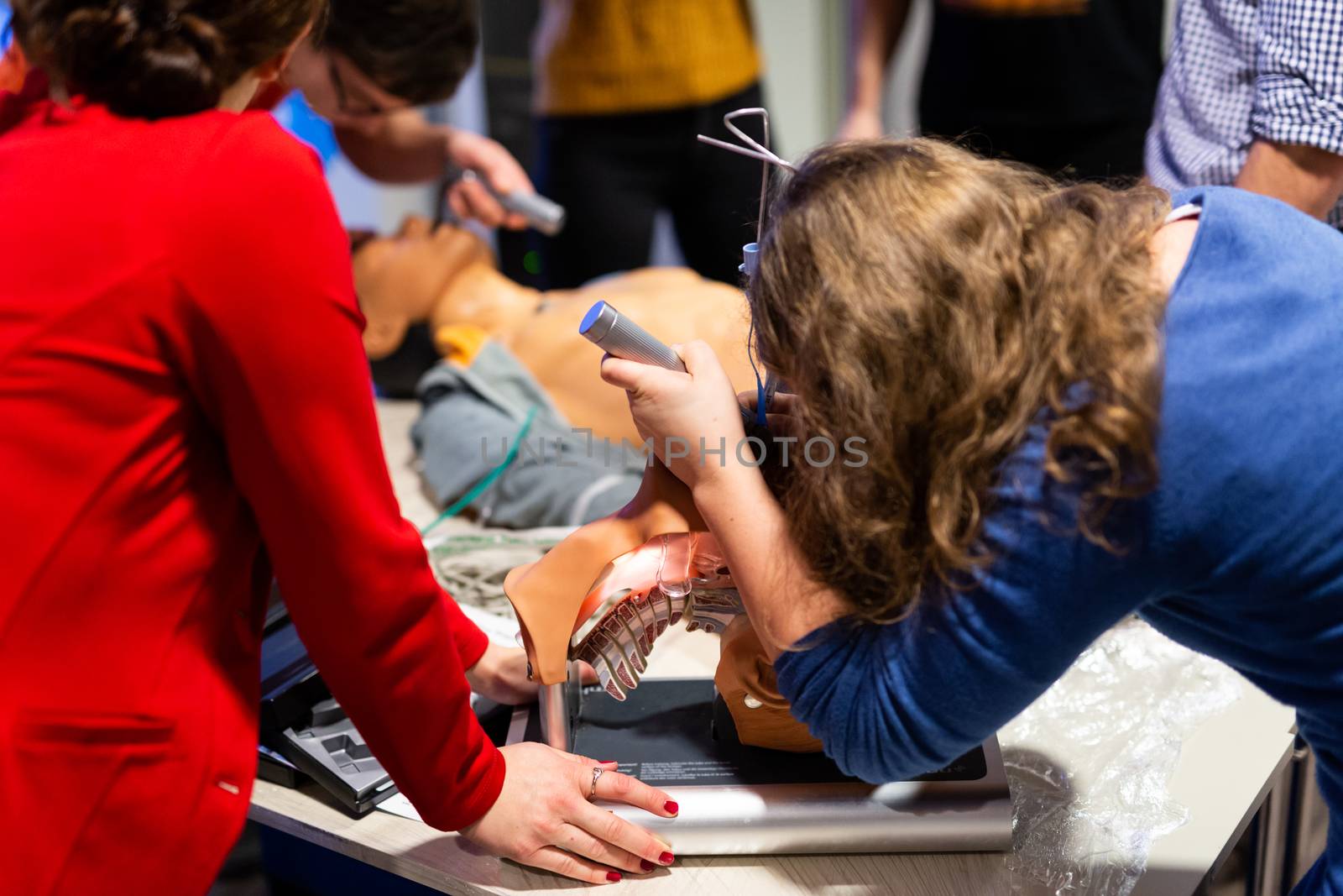 Medical doctor expert instructor displaying method of patient intubation on medical education training and workshop. Participants working in teams learning new medical procedures and techniques.