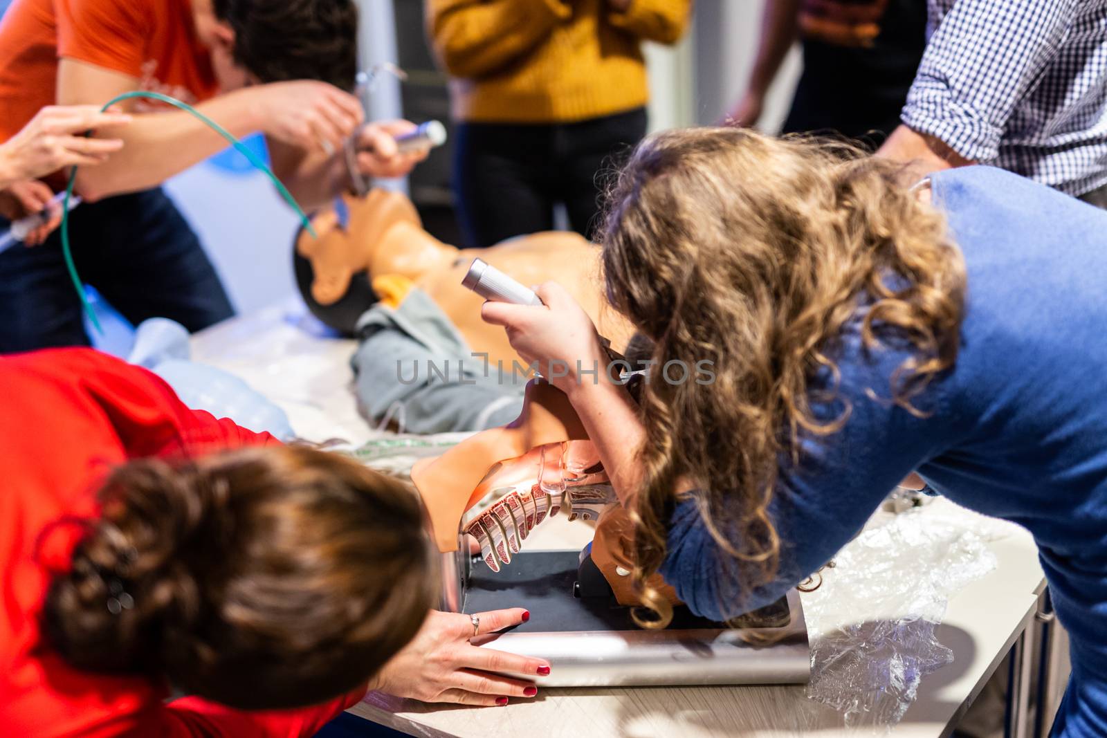 Medical doctor expert instructor displaying method of patient intubation on medical education training and workshop. Participants working in teams learning new medical procedures and techniques.