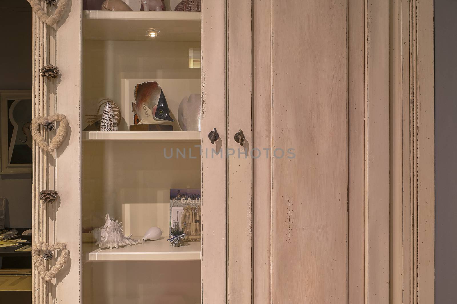 Detail of the doors of a vintage wooden wardrobe, with a small door to display travel souvenirs, excellent image for use as a graphic resource!