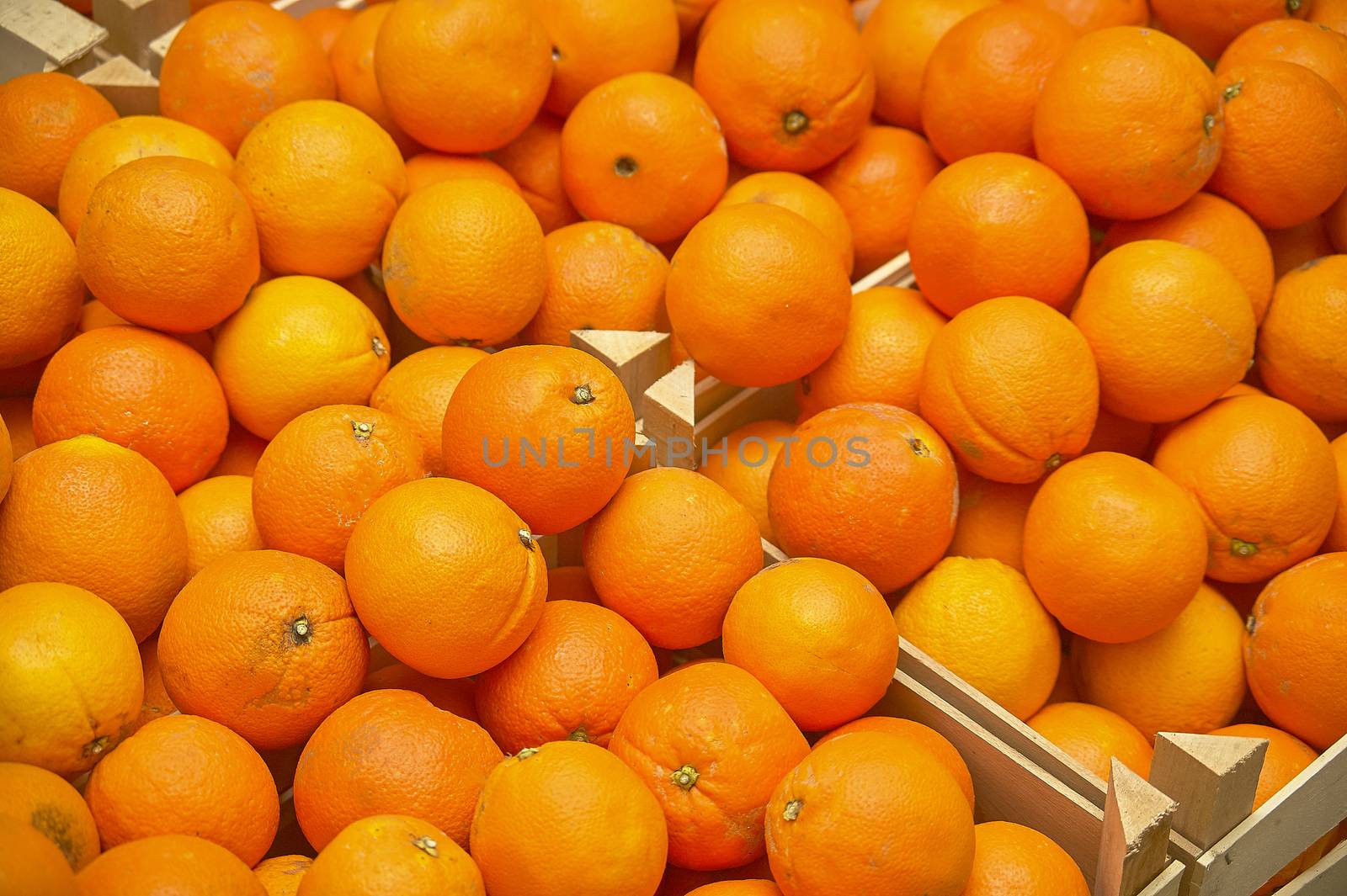 Oranges texture: Storage of oranges inside wooden boxes ready to be sold at the market.