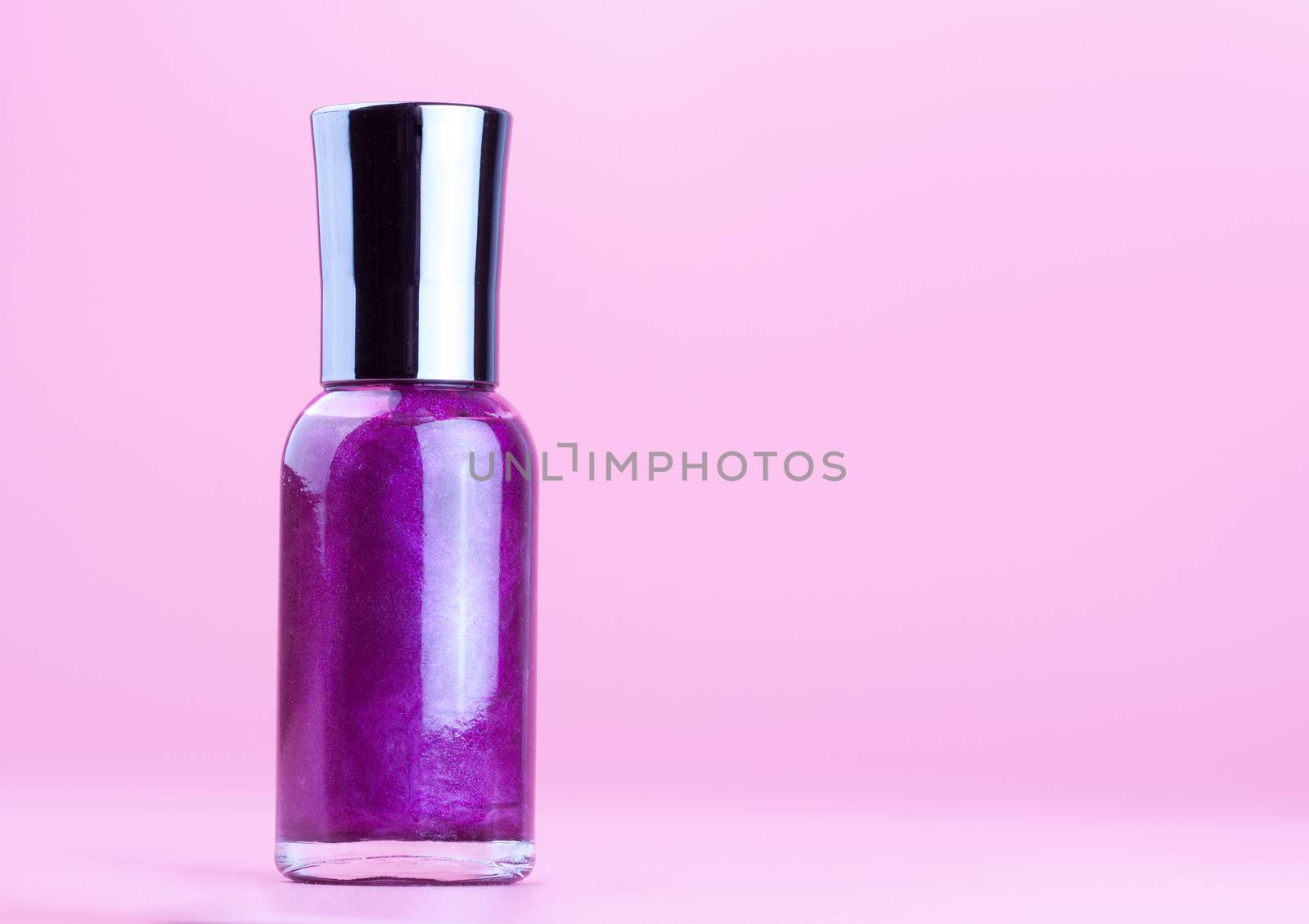 Bottle of purple nail polish on white background