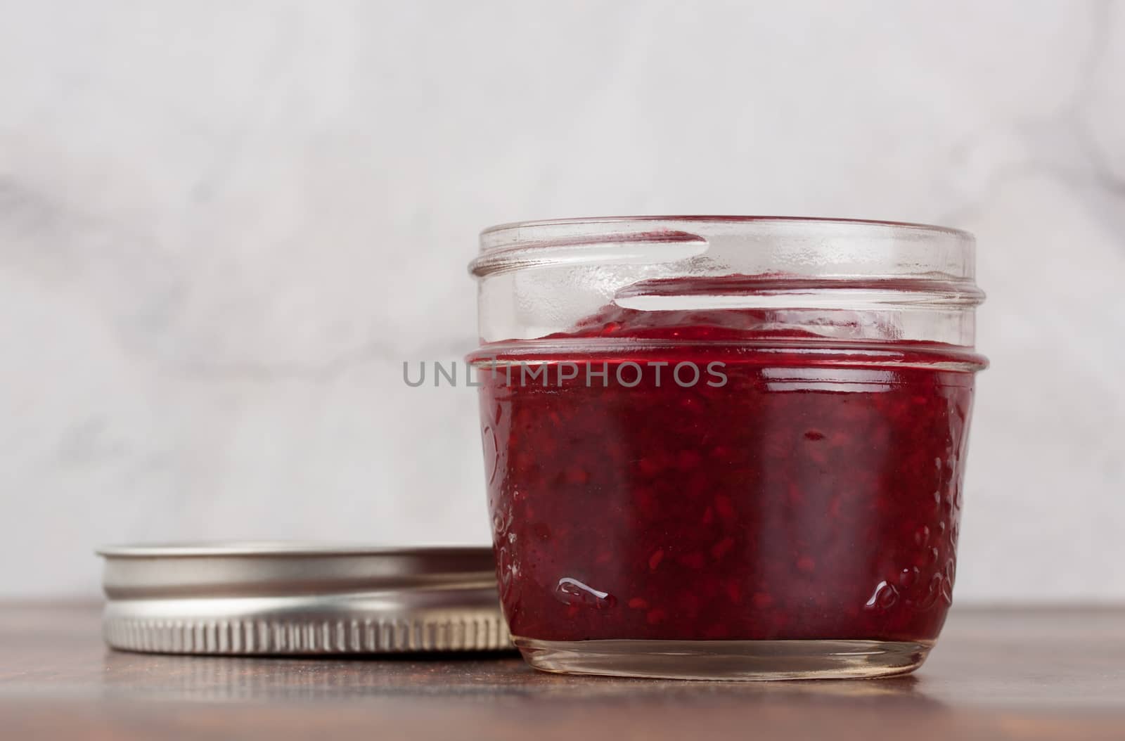 Delicious homemade raspberry jam in a reusable glass jar
