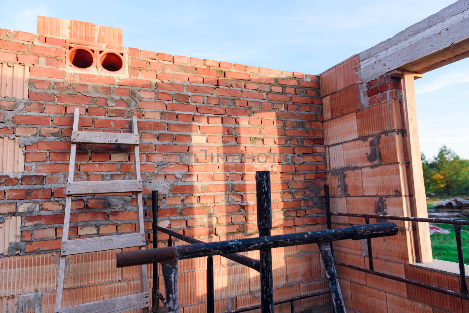 Interior of a Unfinished Red Brick House Walls under Construction without Roofing.