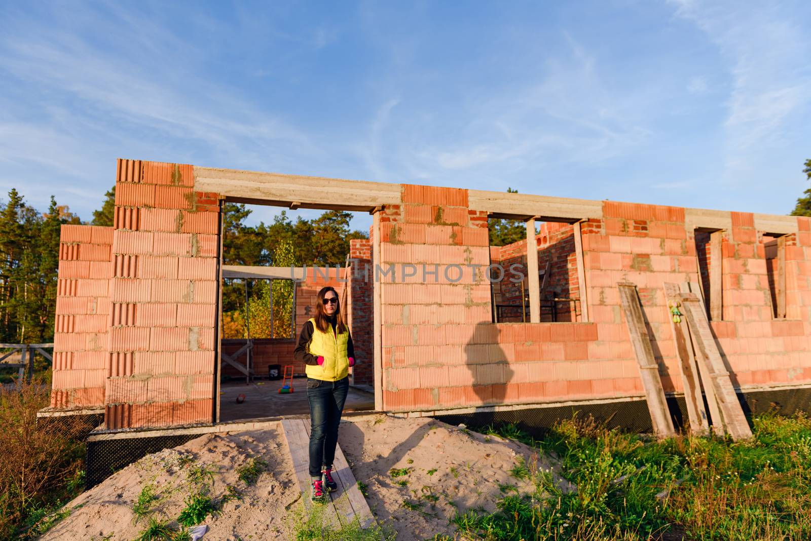 Exterior of a Unfinished Red Brick House Walls under Construction without Roofing.