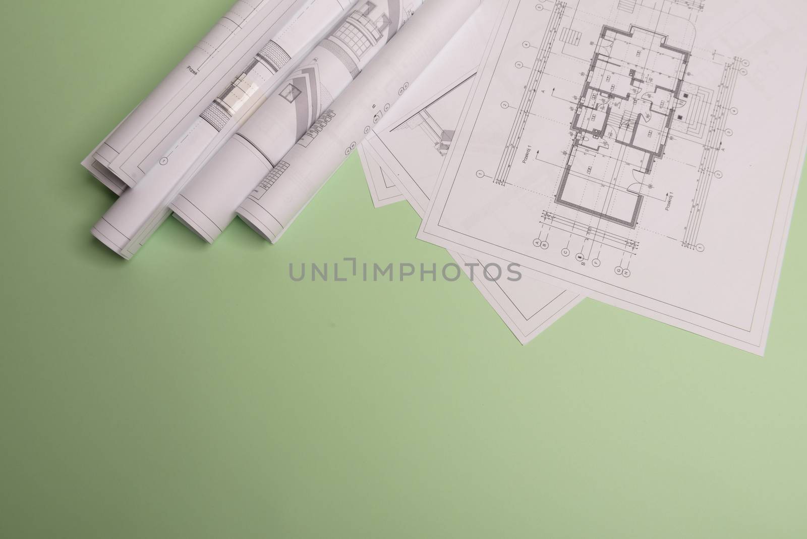 White family paper house , stack of money coins, house projects plan and blueprints on mint background paper. Minimalistic and simple concept, style. Horizontal orientation