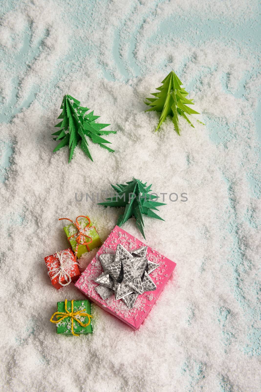 christmas presents nicely decorated with bows and feathers in snow. view from above