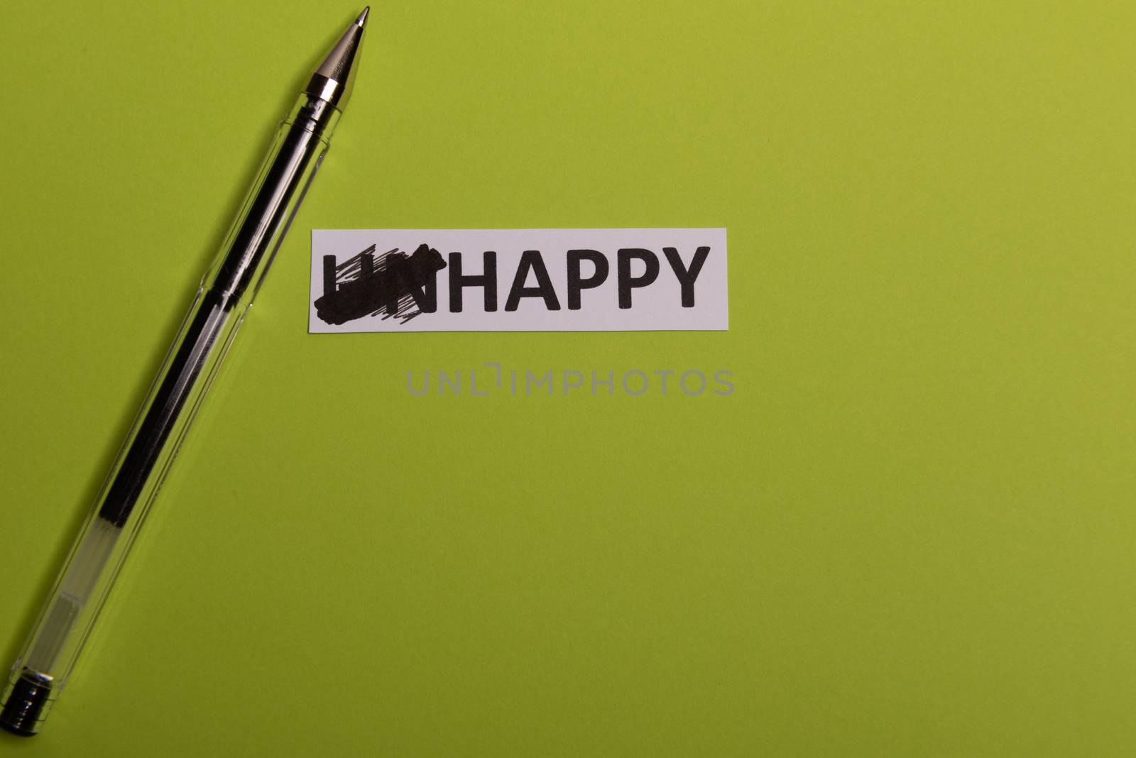 card with text unhappy, erease word 'un' so it written 'happy'. Copy space. Lime background. Studio shoot.