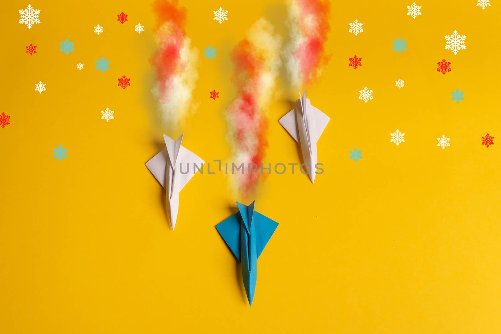 Group of paper plane in one direction and with one individual pointing in the different way on yellow background. Smoke coming out from aircraft tails