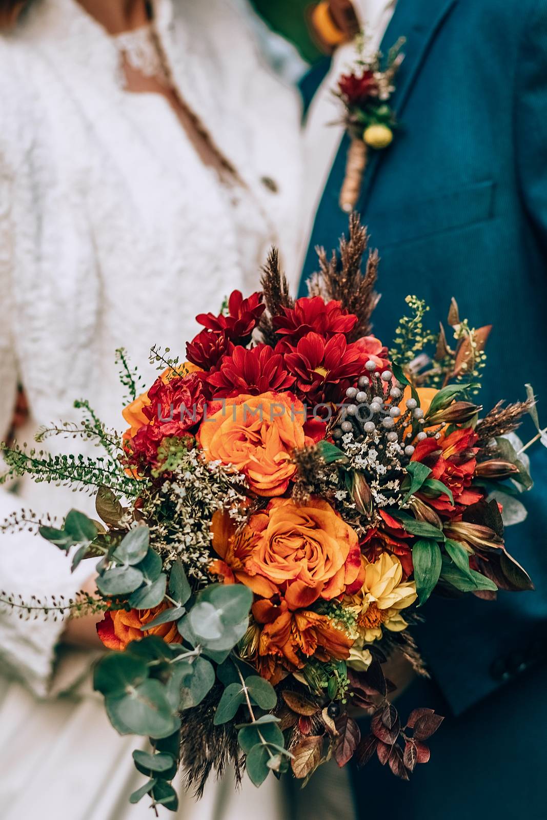 Amazing wedding bouquet with vibrant flowers and green and brown herbs by 3KStudio