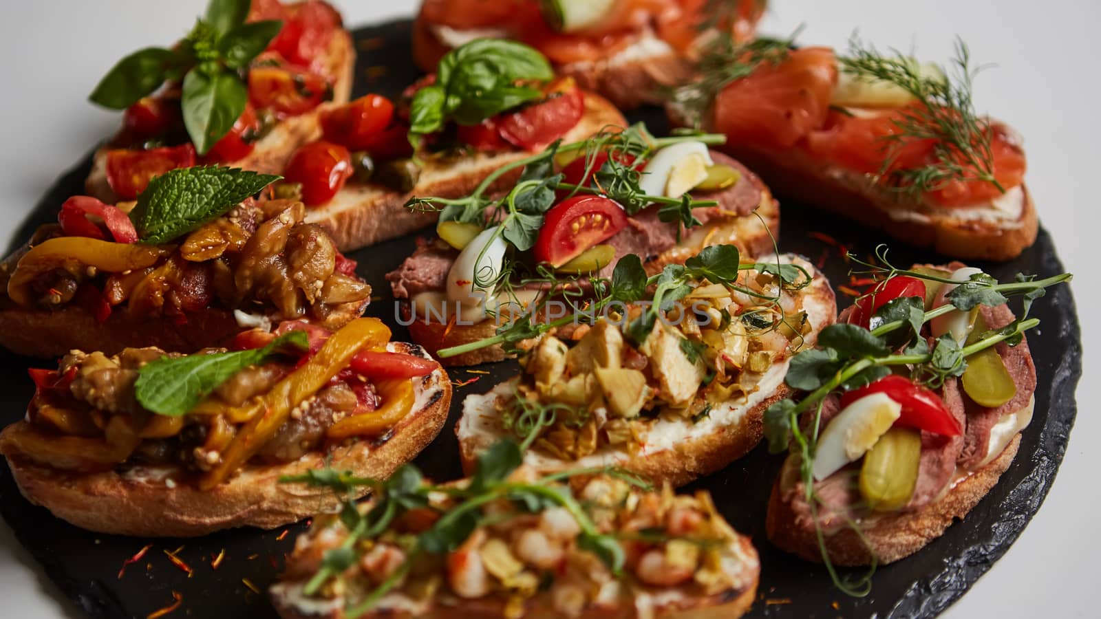 Set of assorted bruschetta with various toppings for holiday on board. Top view. Party food concept.