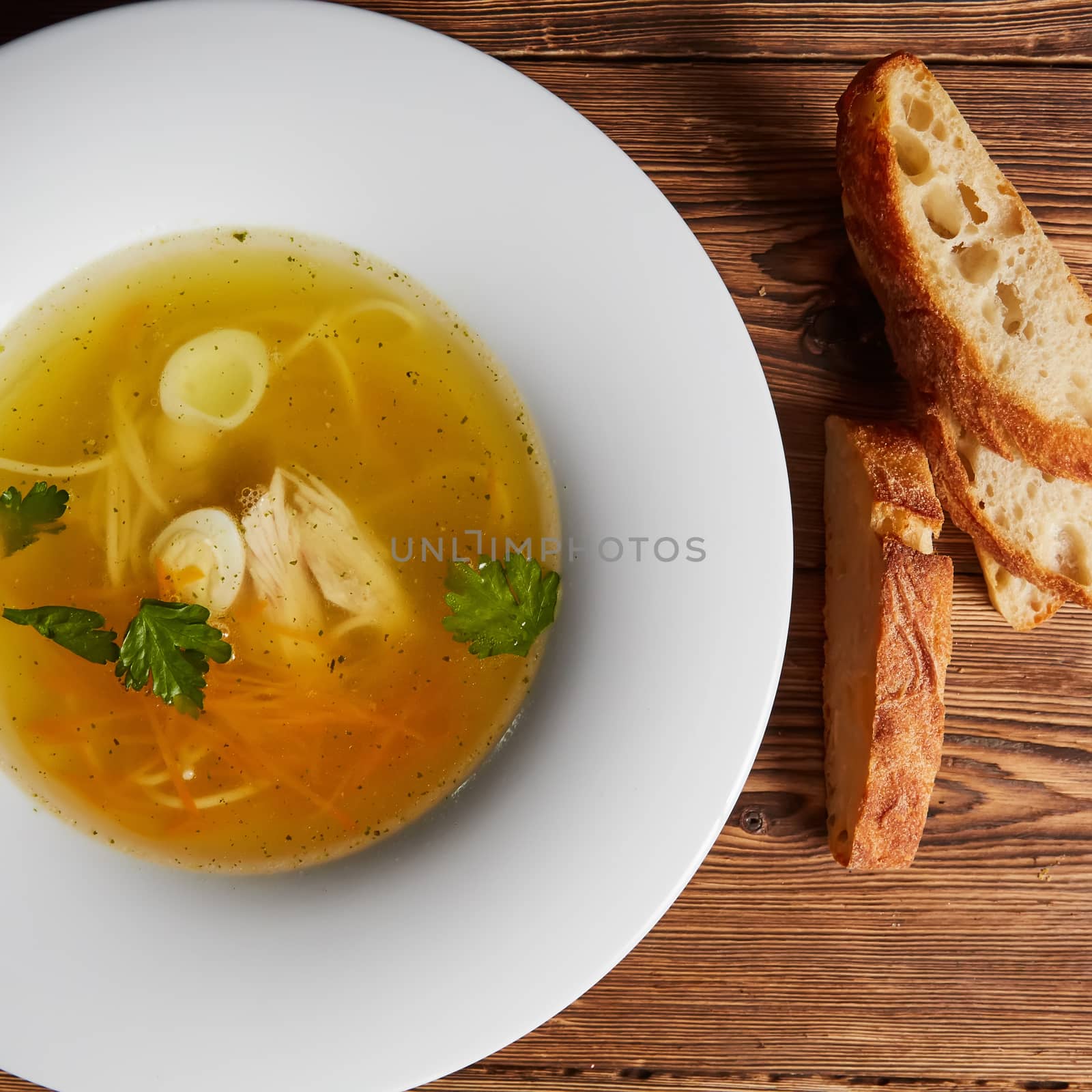 Meat broth with chicken meat, egg and parsley in a white bowl, b by sarymsakov