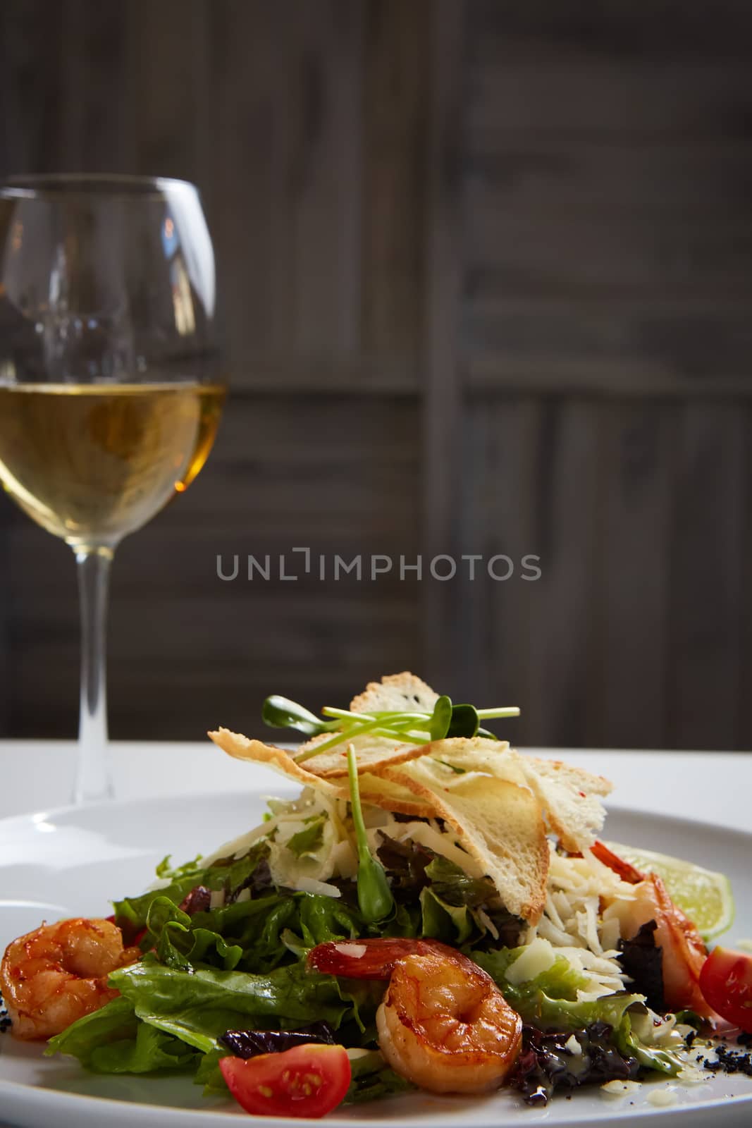 Fresh caesar salad on white bowl with parmesan cheese and shrimp by sarymsakov
