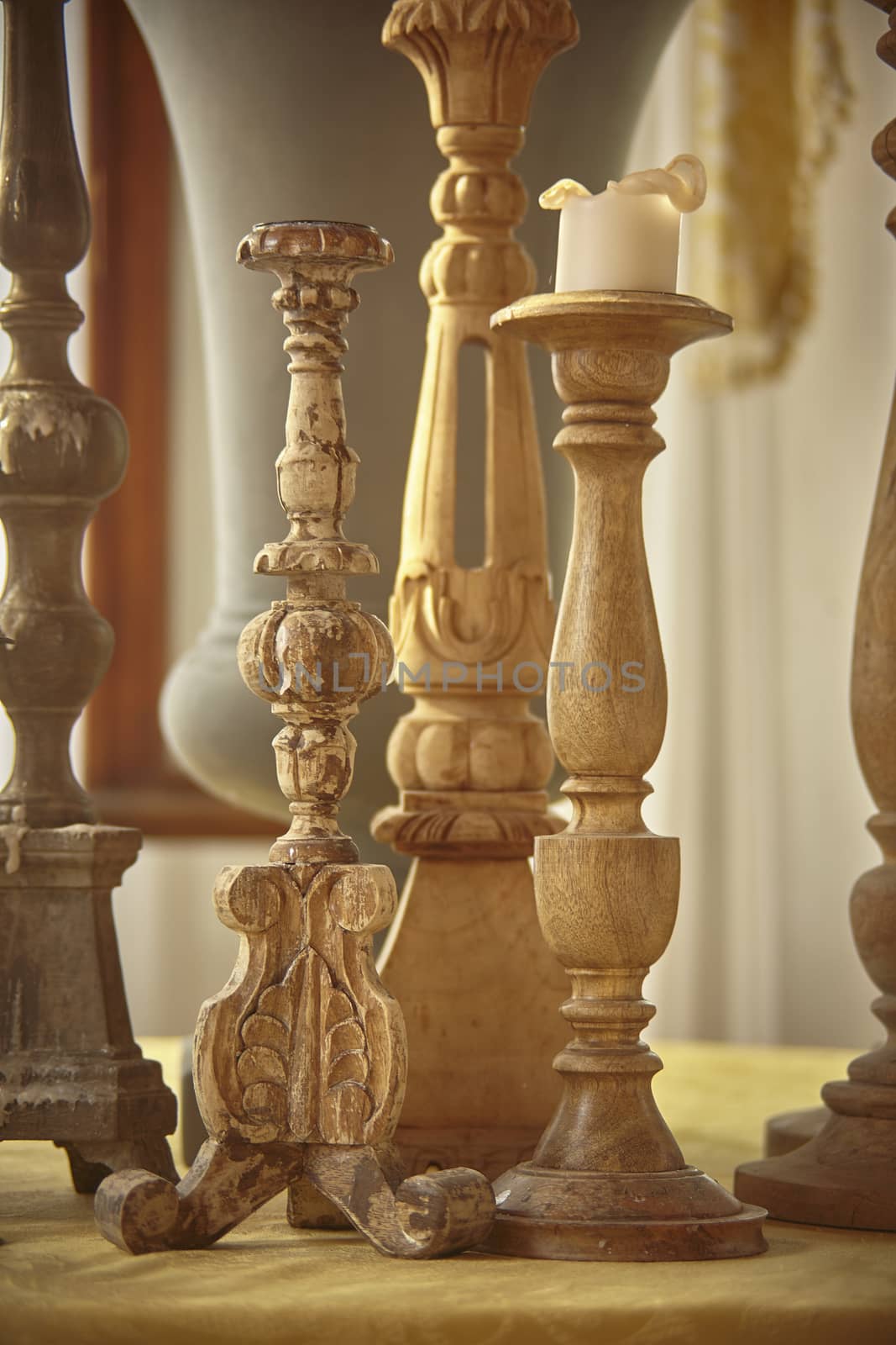 Vertical shot with vintage handmade wooden candlesticks used as furniture items.