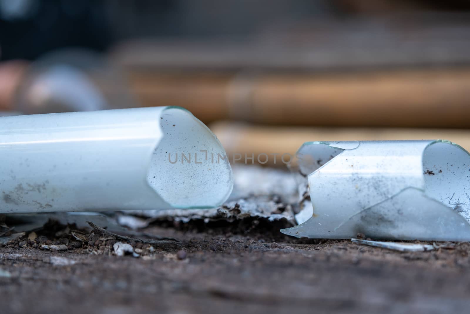 Select focus Pile of broken fluorescent light bulb is danger for health with blur background by peerapixs