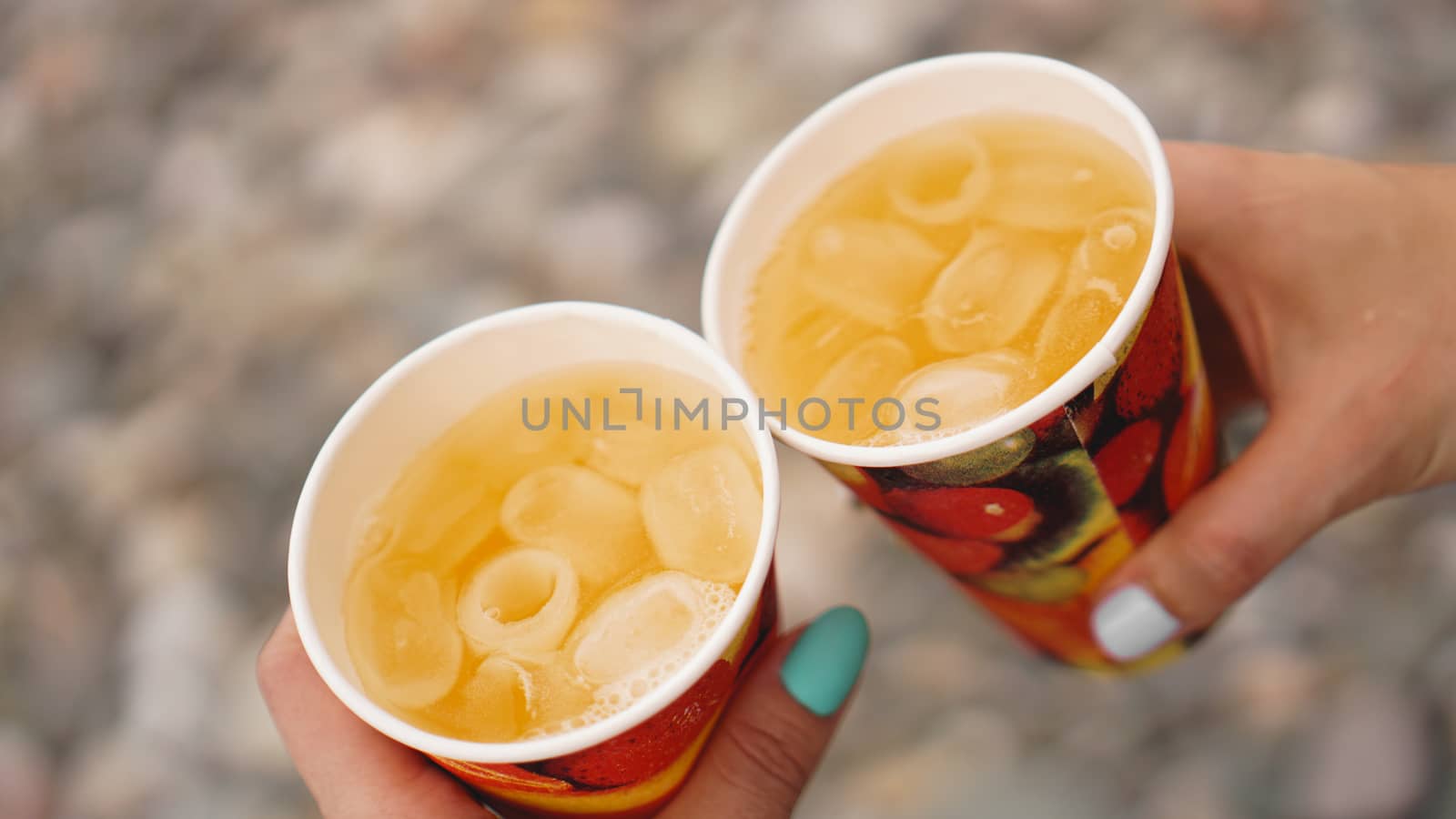 Male hand holding paper cup with lemonaide by natali_brill