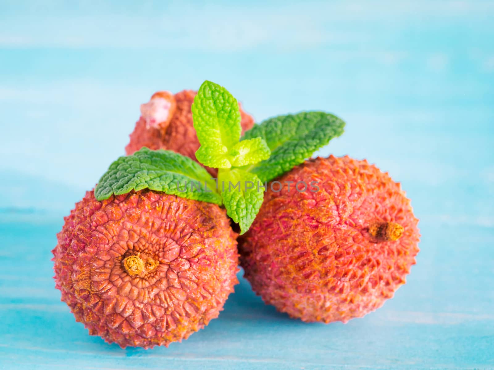 lichee fruit on turquoise wooden background close up
