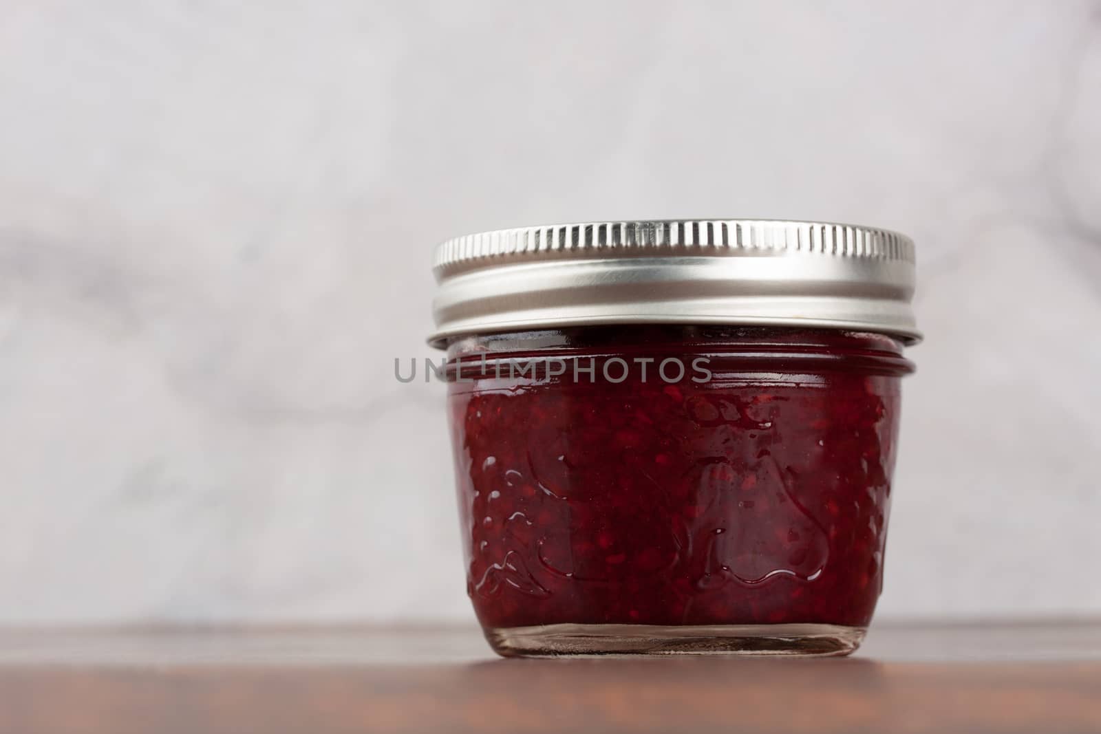 Delicious homemade raspberry jam in a reusable glass jar