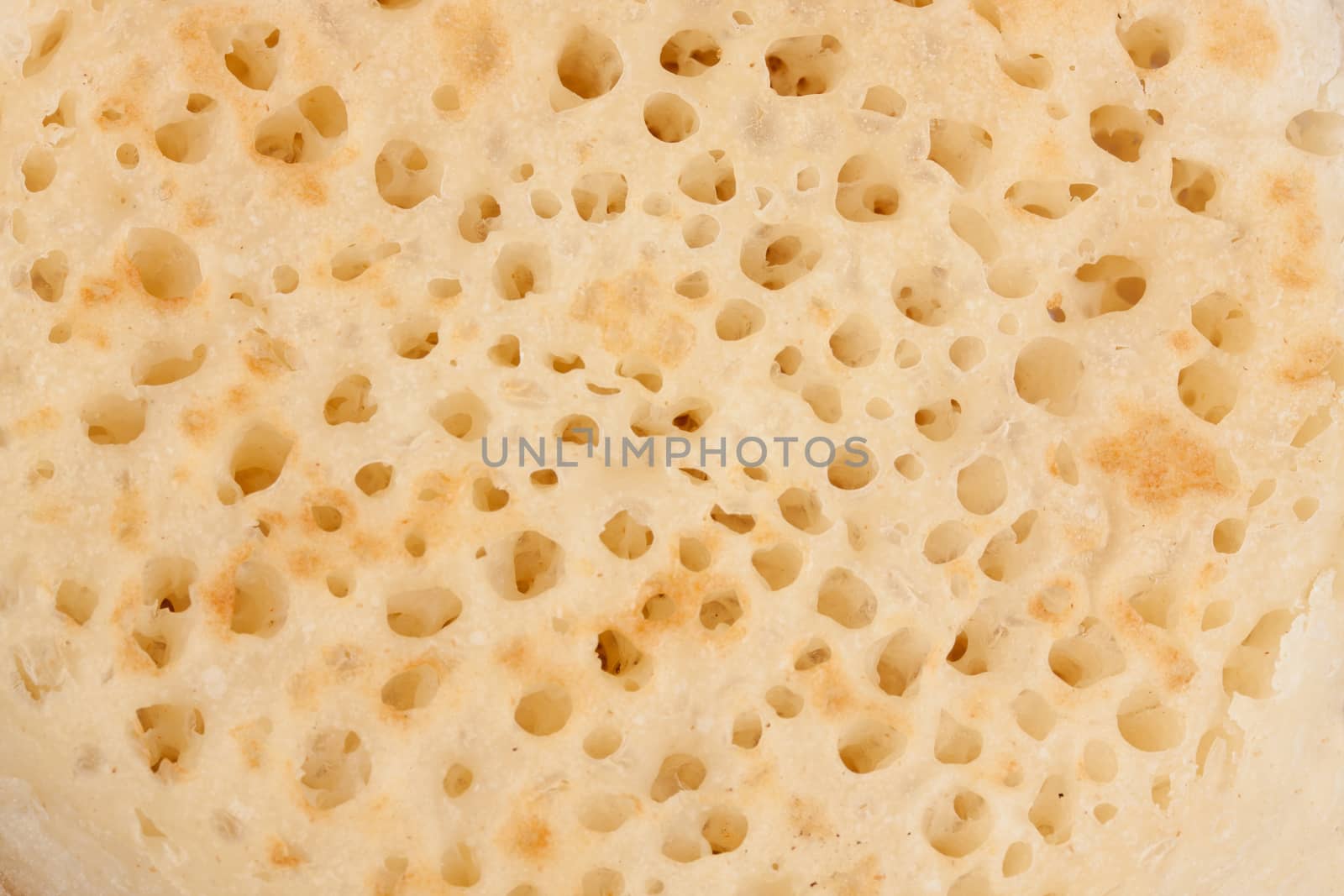 Closeup on texture of a British crumpet by lanalanglois