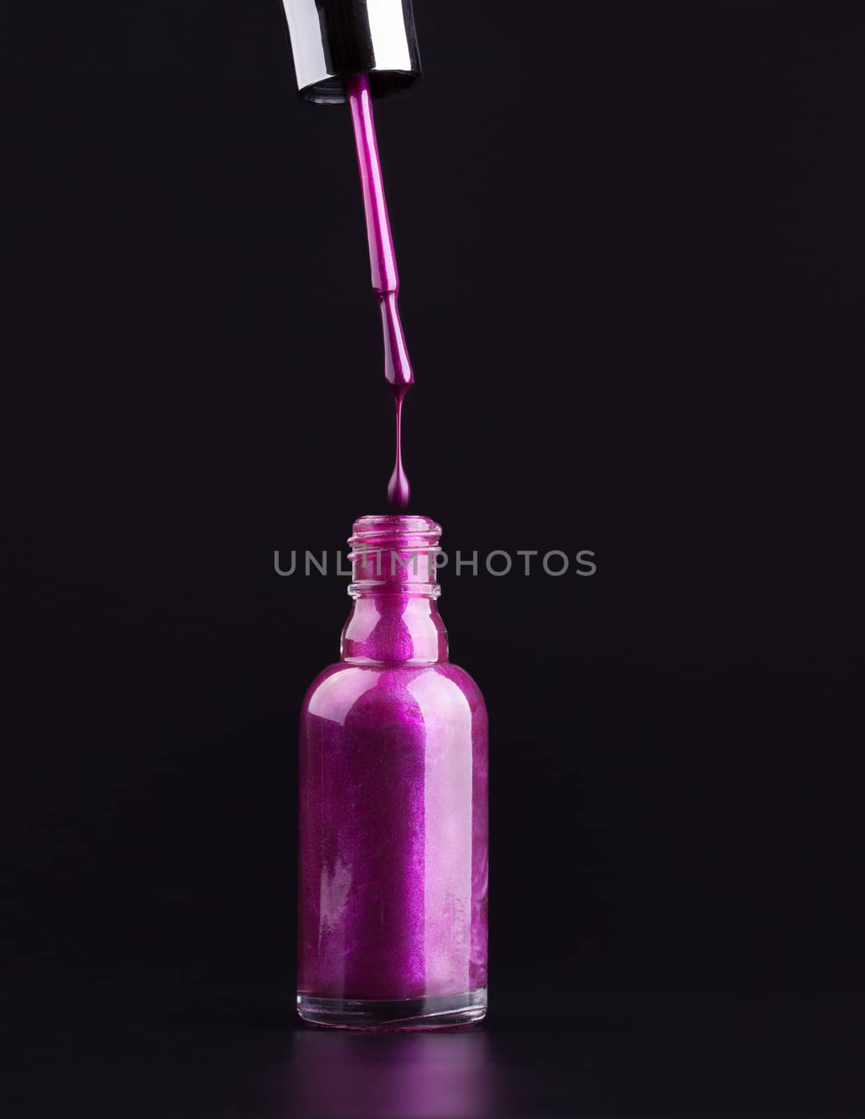 opened bottle of purple nail polish dripping