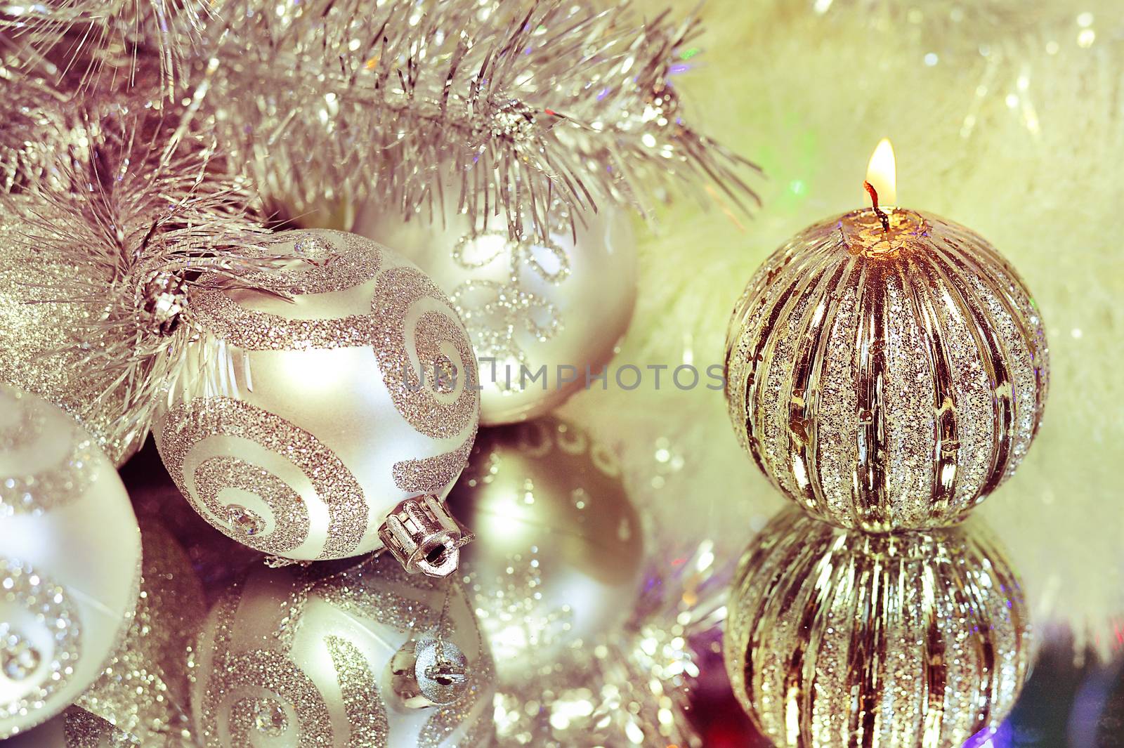 Christmas decorations with candle and silver balls on the mirror.