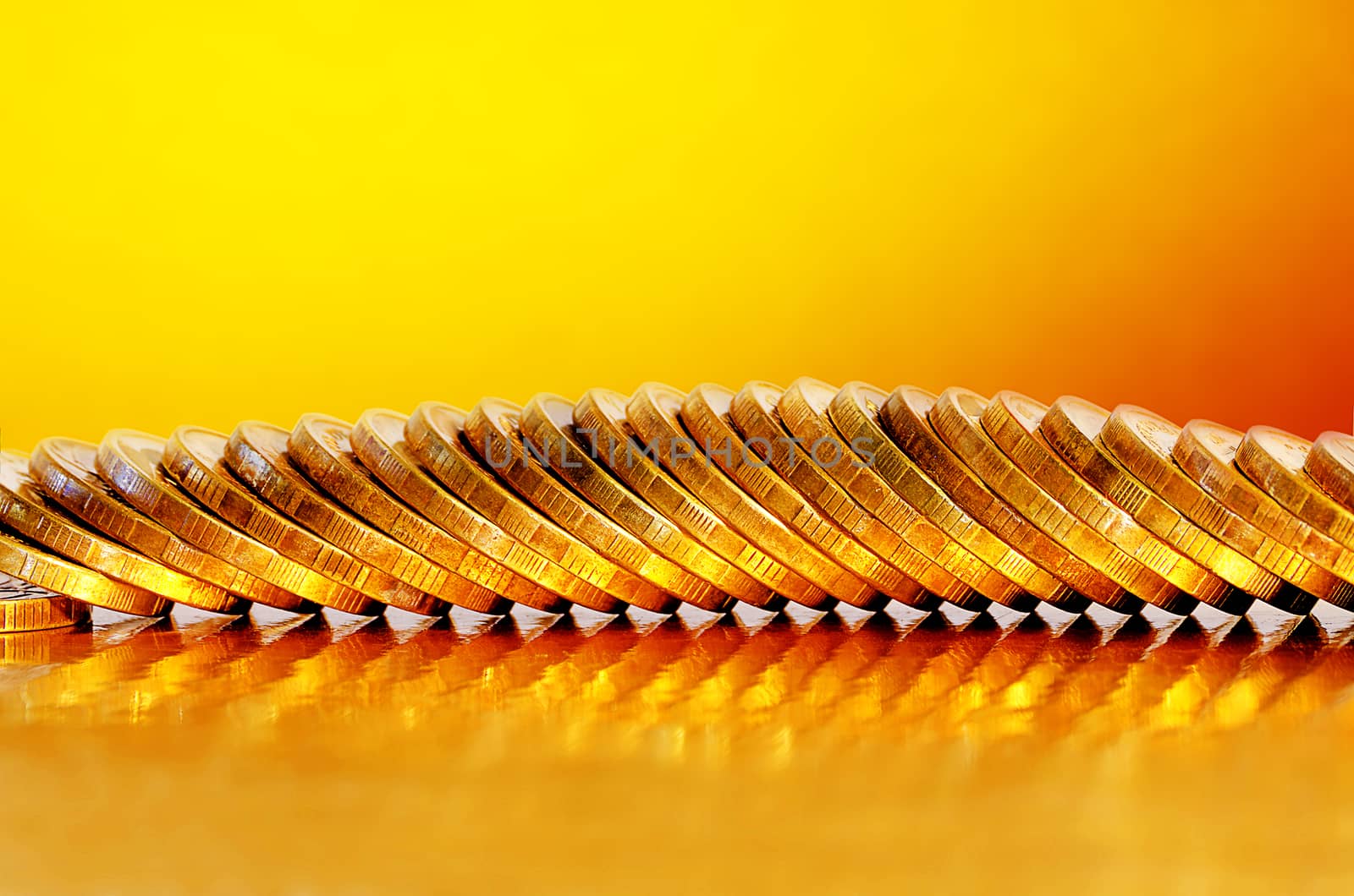 A number of coins lying on the Golden surface with a Golden background