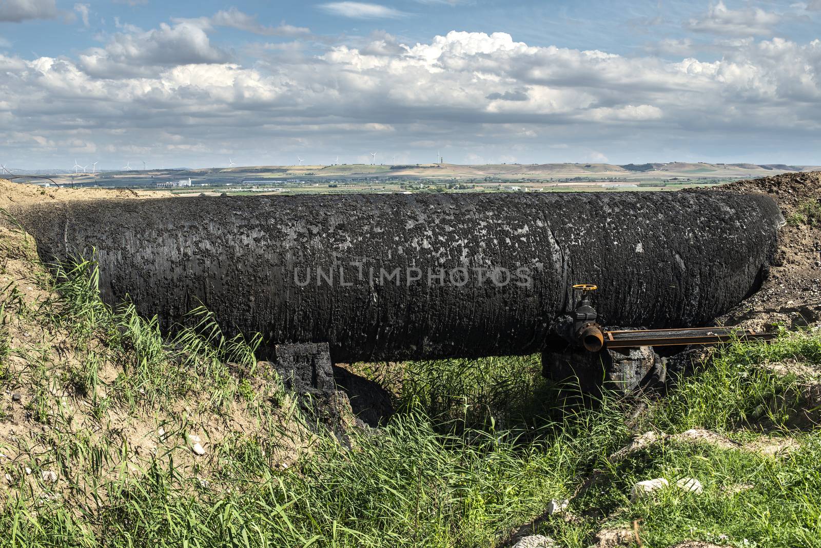 Black Oil pipeline goes out above the ground. Oil-stained pipe.  by deyan_georgiev