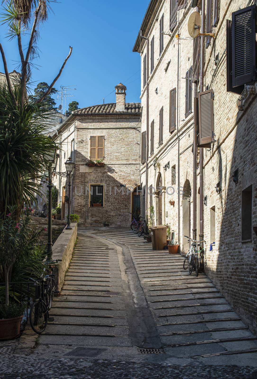 Old buildings on small italian street. Narrow street in Italy. Flowers in front of vintage houses.